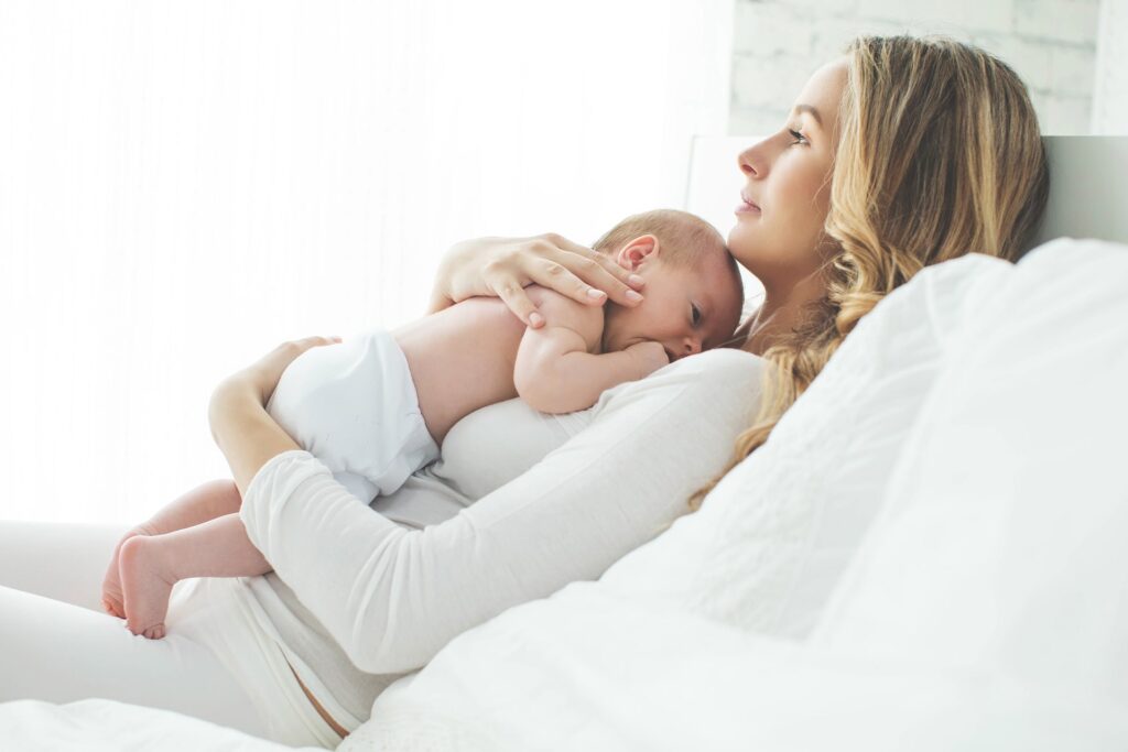Blonde woman and baby in bed